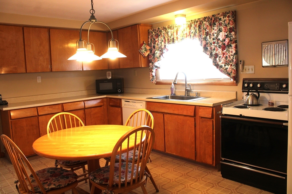 24 Metzger Place Springfield, MA 01104 - Photo 5 of 35 a kitchen with a table chairs sink and stove