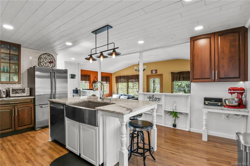 a kitchen with stainless steel appliances granite countertop a sink a stove and chairs