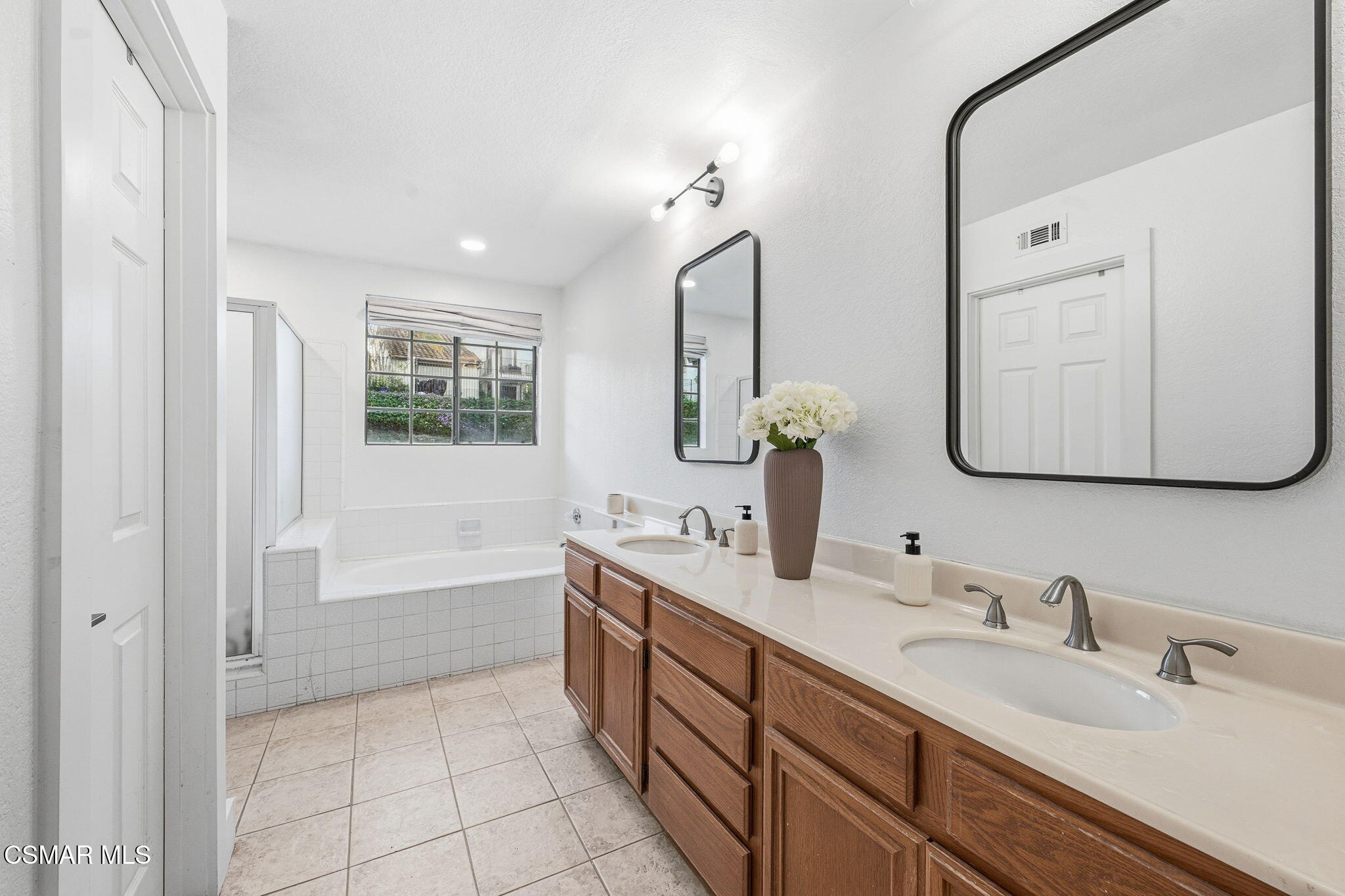 847 Links View Drive Simi Valley, CA 93065 - Photo 27 of 45 a bathroom with a double vanity sink a mirror and a bathtub