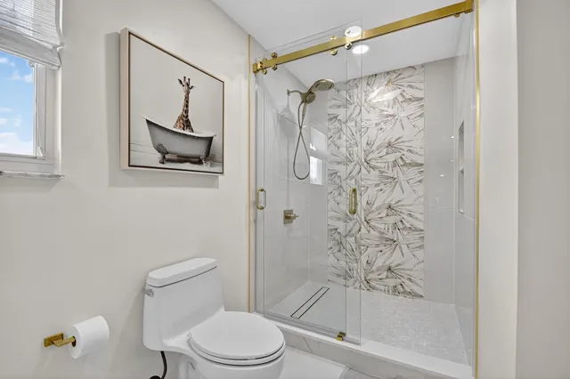 a white toilet sitting next to a shower