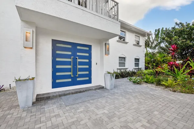 a view of a house with potted plants and a garage