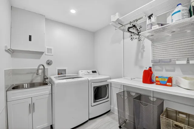 a utility room with sink dryer and washer