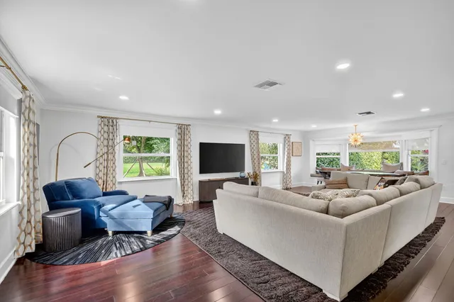 a living room with furniture flat screen tv and a large window