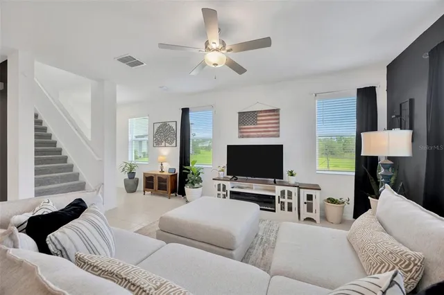 a living room with furniture a chandelier and a flat screen tv