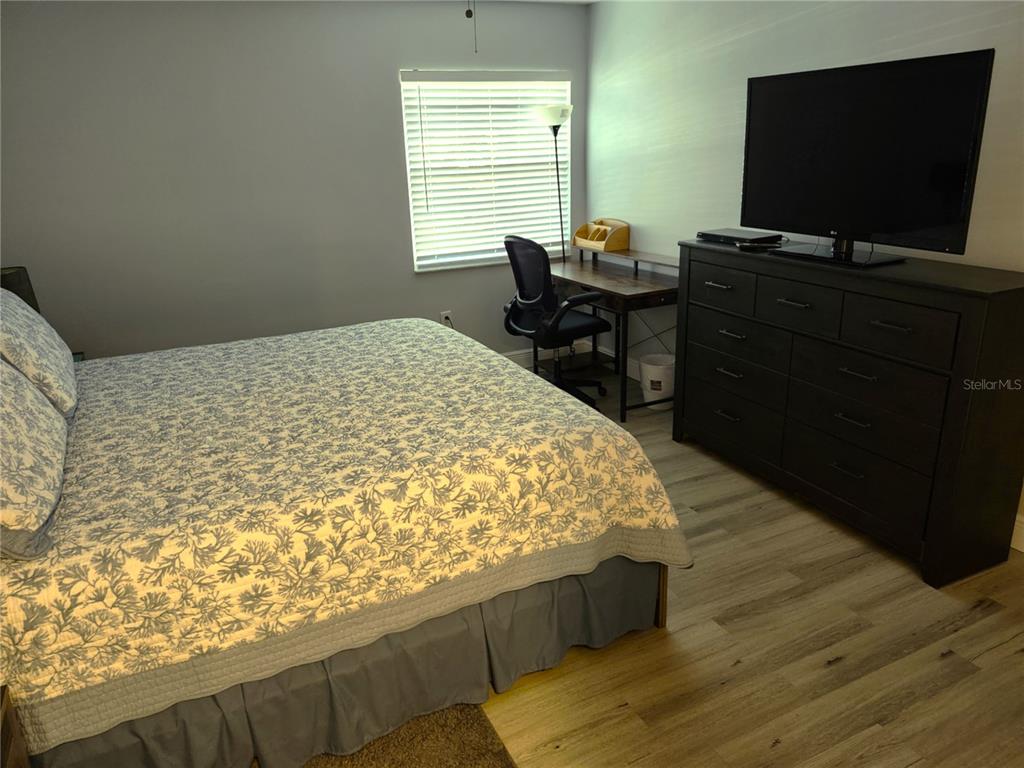 3251 South Beneva Road, Unit 101 Sarasota, FL 34232 - Photo 20 of 22 a bedroom with a bed and a flat screen tv