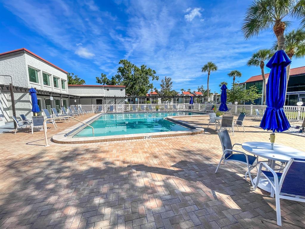 3251 South Beneva Road, Unit 101 Sarasota, FL 34232 - Photo 6 of 22 a view of pool with lawn chairs and potted plants