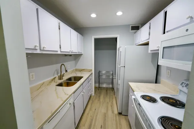 a kitchen with a refrigerator a sink and a cabinets