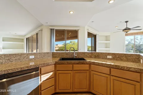 a kitchen with granite countertop cabinets sink and window