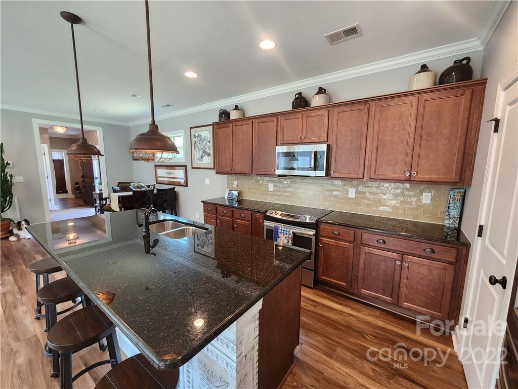 192 Flat Rock Drive Denver, NC 28037 - Photo 10 of 32 a kitchen with kitchen island granite countertop wooden cabinets a stove a sink and a refrigerator