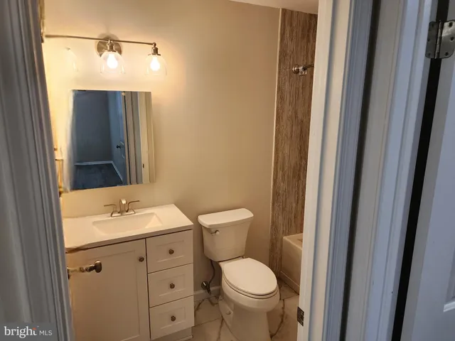 a bathroom with a toilet a sink and mirror