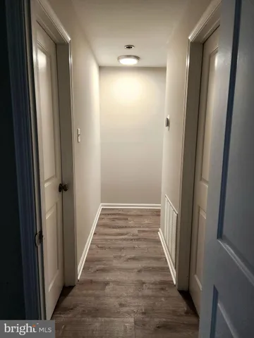 a view of a hallway with wooden floor and staircase