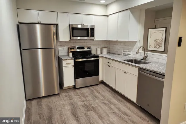 a kitchen with stainless steel appliances a refrigerator sink and microwave