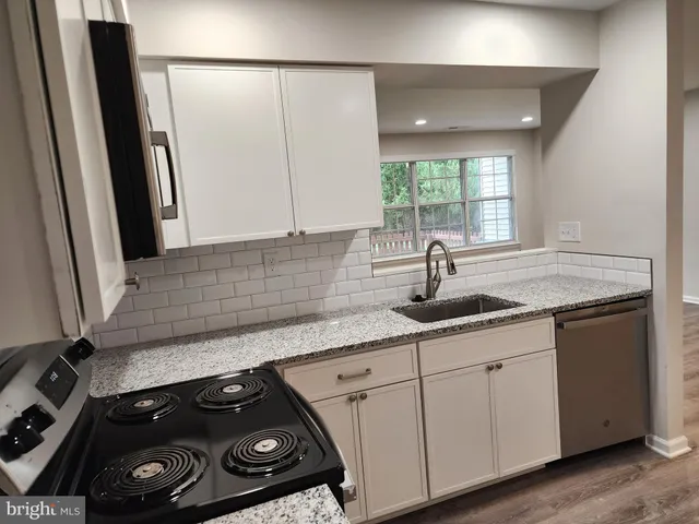 a kitchen with a sink stove and cabinets