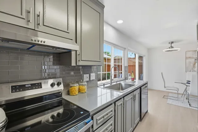 a kitchen with stainless steel appliances granite countertop a sink and a stove
