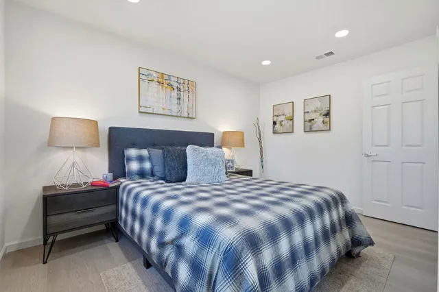 a bedroom with a bed and a painting on the wall