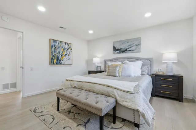 a bedroom with a bed and painting on the wall