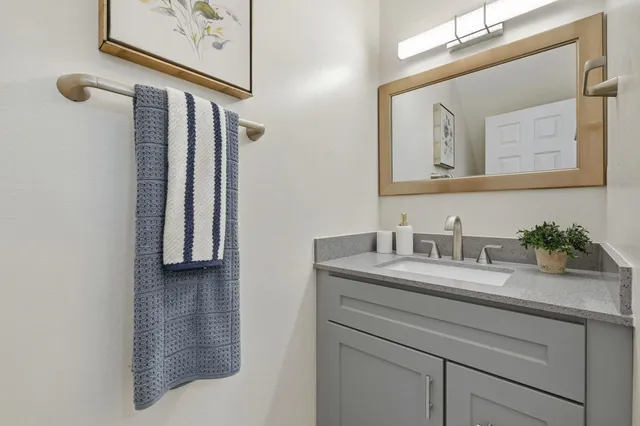 a bathroom with a granite countertop sink and a mirror