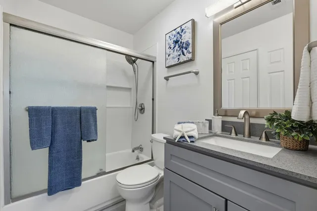 a bathroom with a granite countertop sink toilet and shower