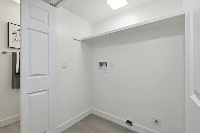 a small space with wooden floor and a window