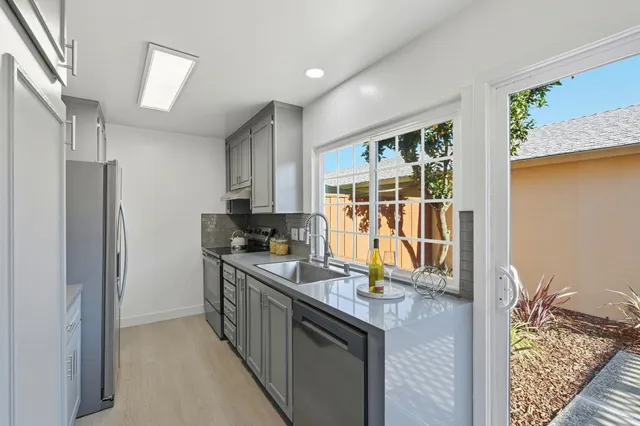 a kitchen with granite countertop a sink stove and refrigerator