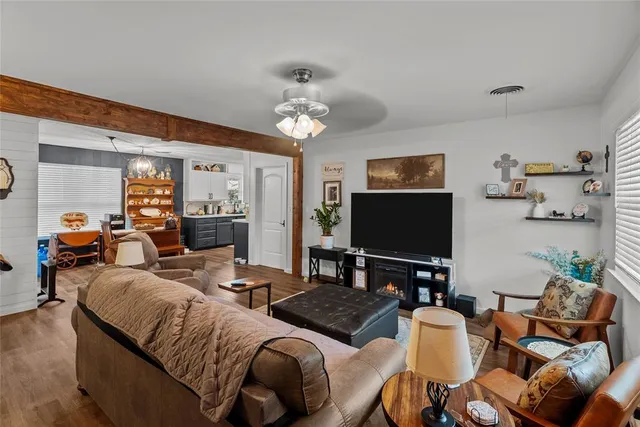 a living room with furniture a flat screen tv and a large window