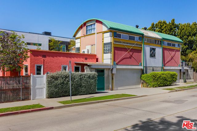 a front view of a house with a yard and potted plants
