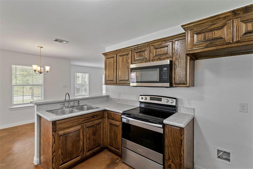 804 East 5th Street Bonham, TX 75418 - Photo 3 of 15 a kitchen with stainless steel appliances granite countertop a sink stove and microwave