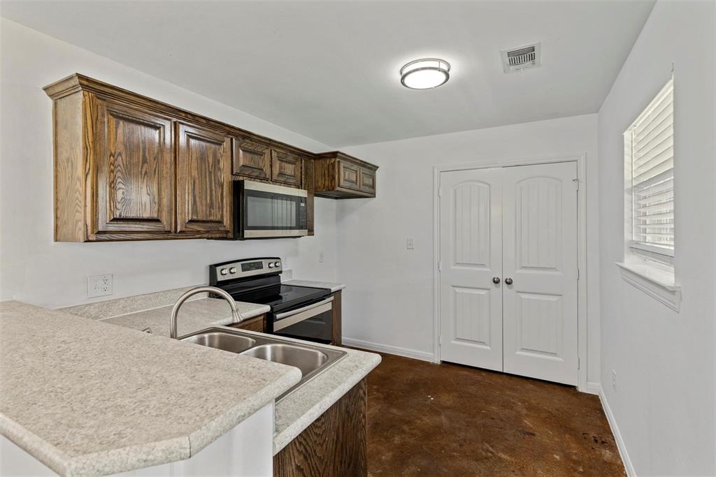 804 East 5th Street Bonham, TX 75418 - Photo 4 of 15 a kitchen with stainless steel appliances granite countertop a sink stove and microwave
