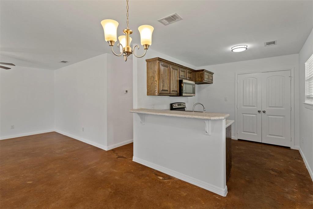 804 East 5th Street Bonham, TX 75418 - Photo 5 of 15 a kitchen with stainless steel appliances granite countertop a sink a stove top oven a counter space and cabinets