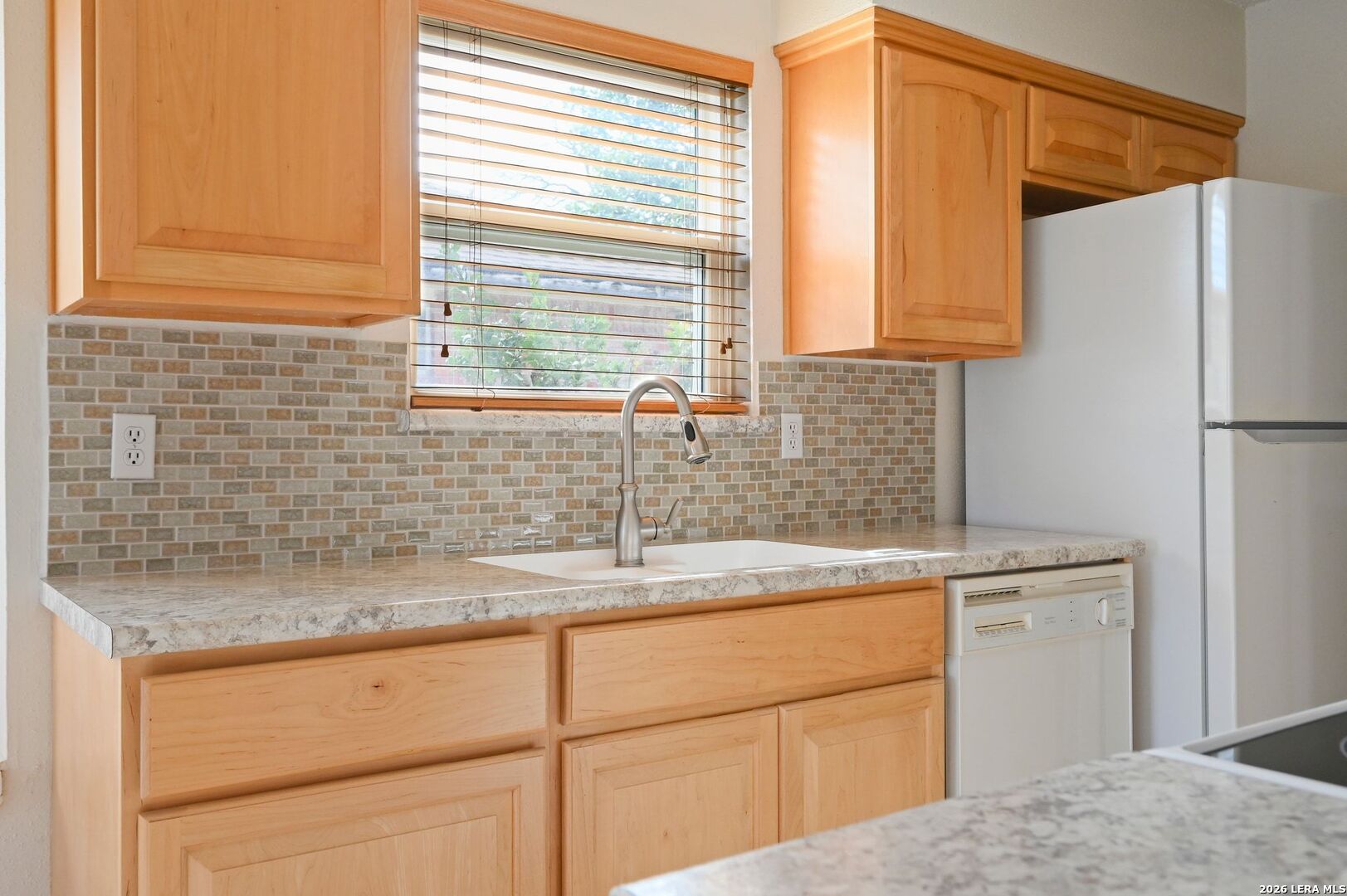 162 Oakside Universal City, TX 78148 - Photo 11 of 31 a kitchen with a sink cabinets and a refrigerator