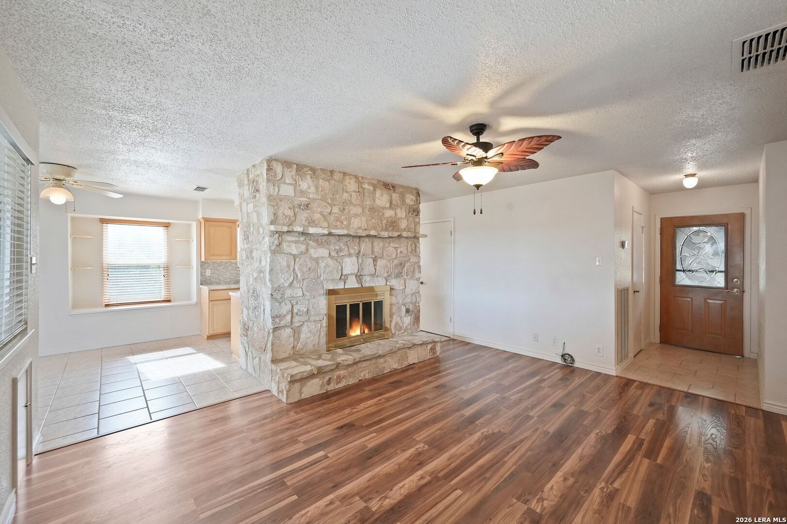162 Oakside Universal City, TX 78148 - Photo 5 of 31 a view of a livingroom with a fireplace a ceiling fan and wooden floor