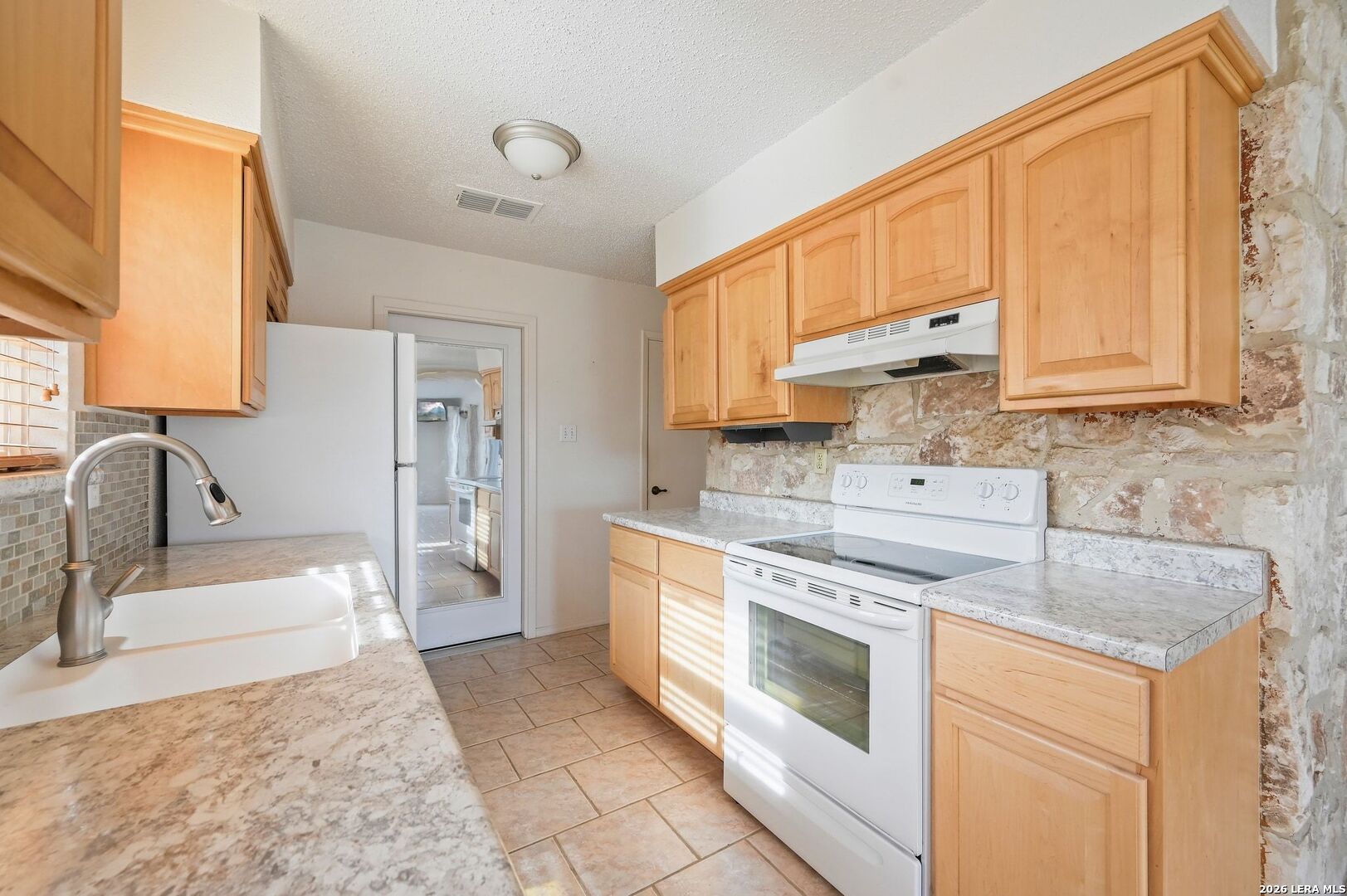 162 Oakside Universal City, TX 78148 - Photo 10 of 31 a kitchen with stainless steel appliances granite countertop a stove a sink and a refrigerator