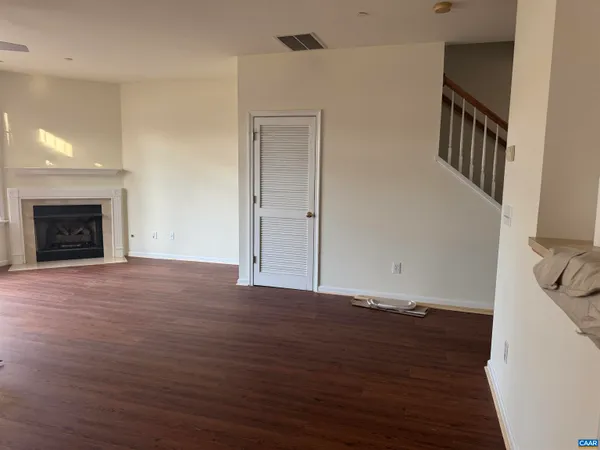 an empty room with wooden floor and fireplace