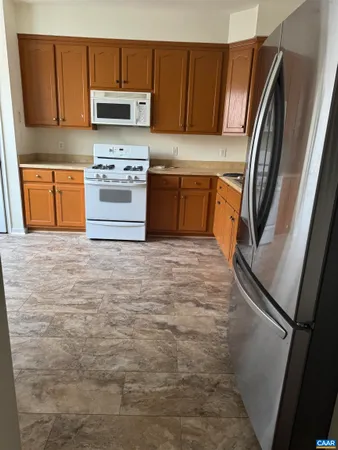 a kitchen with stainless steel appliances granite countertop a refrigerator a stove top oven a sink and dishwasher