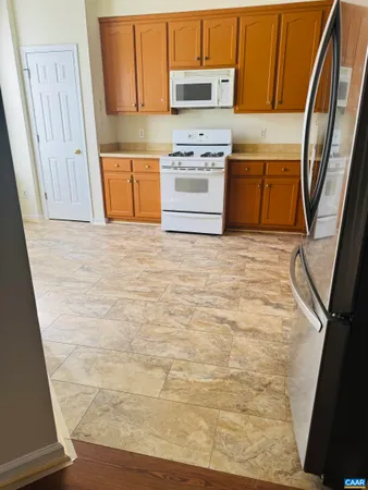 a kitchen with granite countertop a refrigerator stove and sink