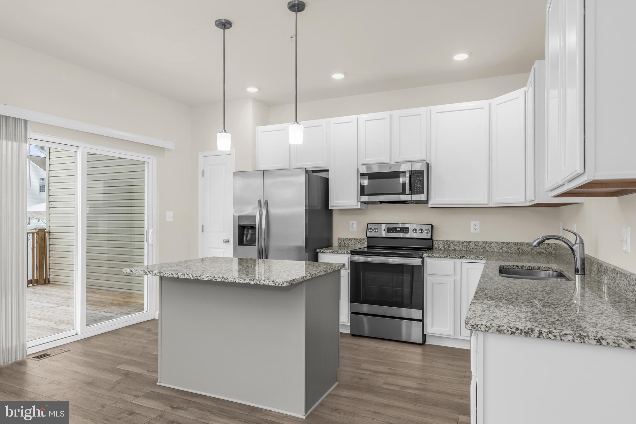 319 Appleby School Road Cambridge, MD 21613 - Photo 11 of 29 a kitchen with stainless steel appliances granite countertop a sink a stove a refrigerator and island with wooden floor