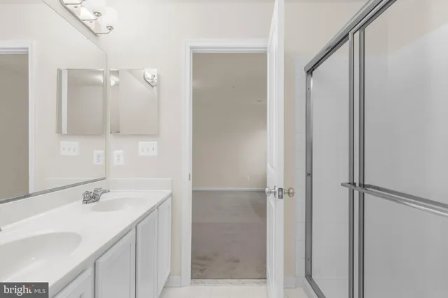 a bathroom with a shower sink and mirror