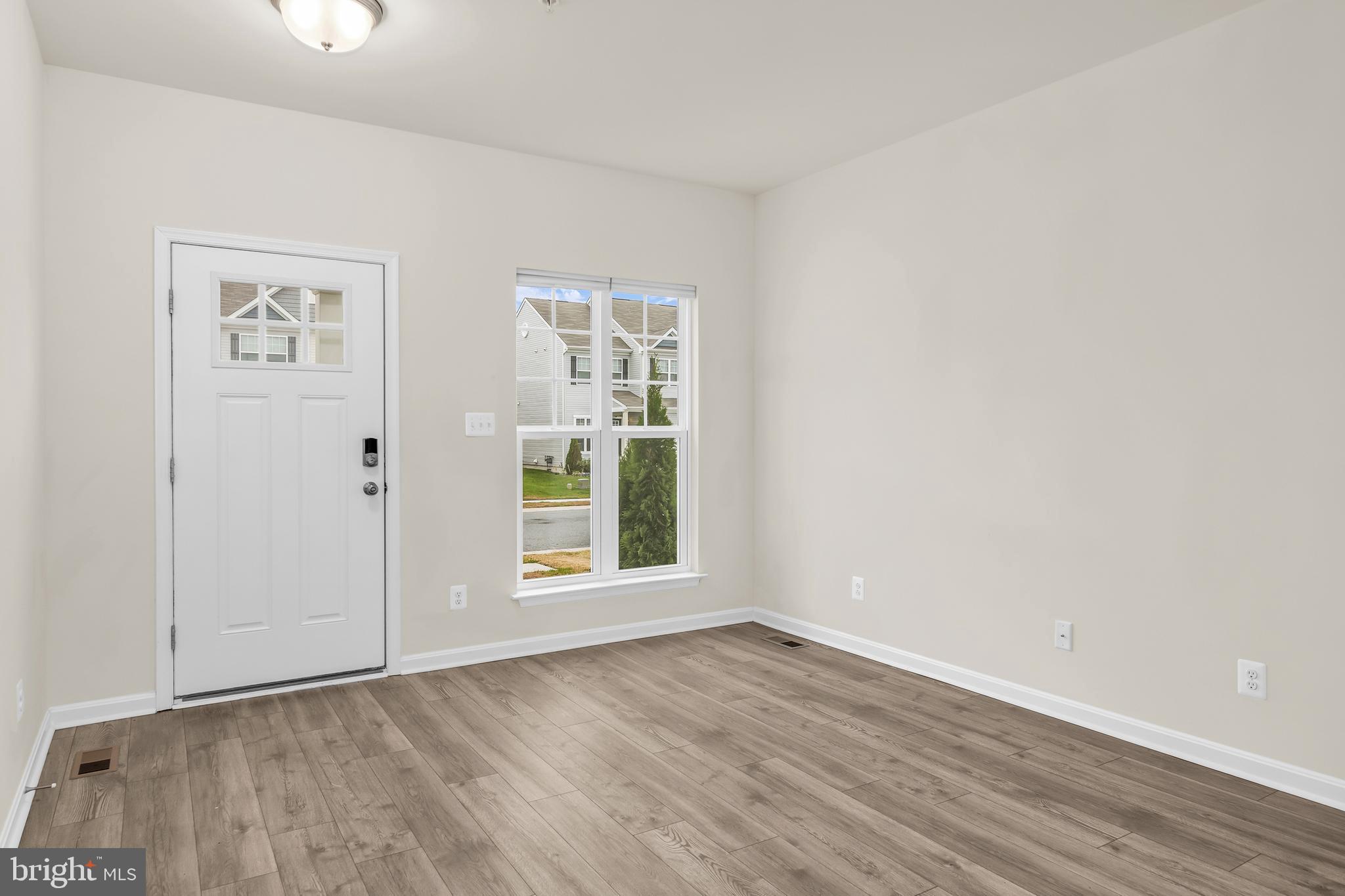 319 Appleby School Road Cambridge, MD 21613 - Photo 7 of 29 an empty room with wooden floor and window