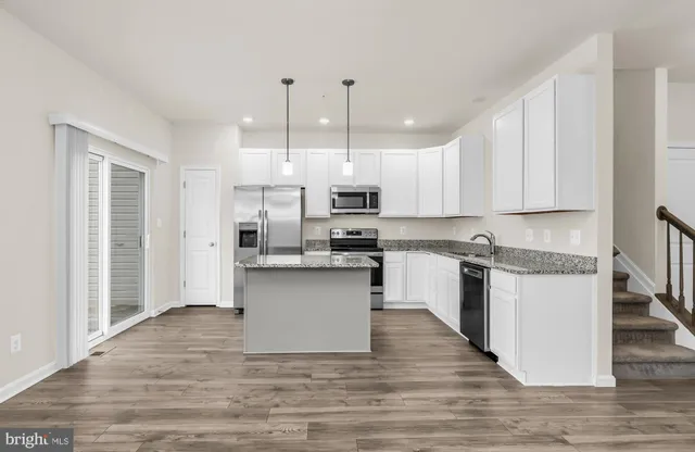 a kitchen with granite countertop a stove top oven and cabinets