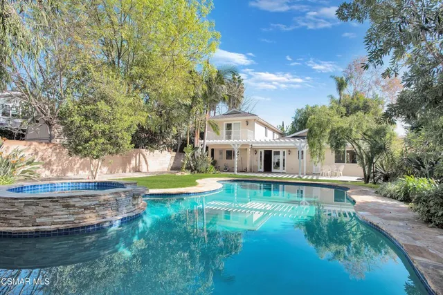 a view of a house with pool and a yard