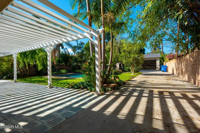 a view of a house with backyard and a tree