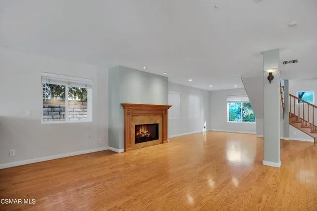 a view of empty room with wooden floor and fireplace