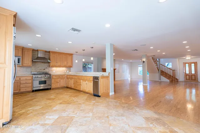 a kitchen with stainless steel appliances a refrigerator sink stove microwave and cabinets