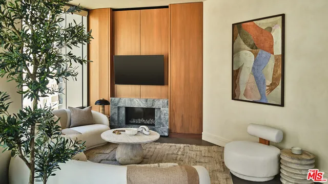 a living room with furniture a flat screen tv and a toilet