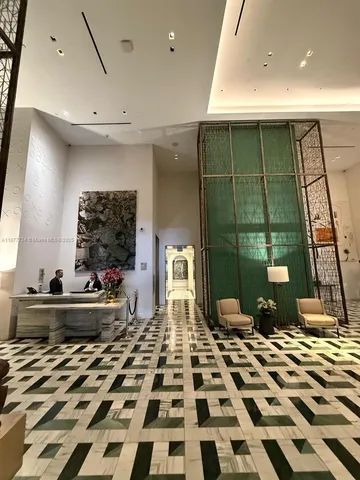 a room with a black white checkered floor with a gaming machine and dining chairs