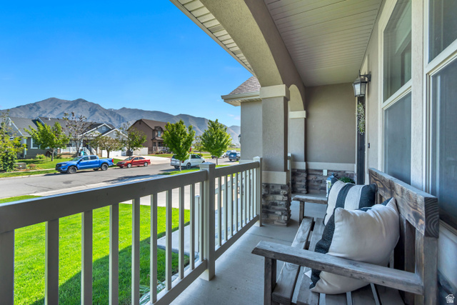 983 West 1550th Street South Springville, UT 84663 - Photo 5 of 43 Covered front porch featuring robust columns with stone accents, a durable railing, and a clear mountain backdrop.