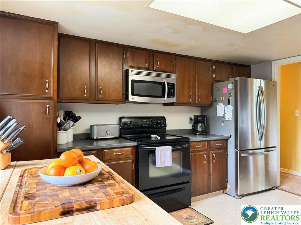 2507 Rachael Lane Orefield, PA 18069 - Photo 11 of 42 a kitchen with stainless steel appliances granite countertop wooden cabinets a stove a microwave and a refrigerator