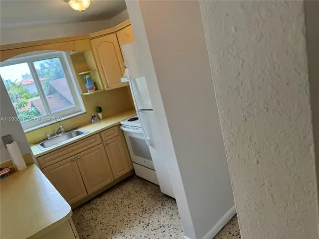 a kitchen with a sink and a stove next to a window