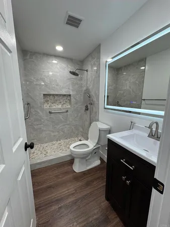 a bathroom with a sink toilet a mirror and shower