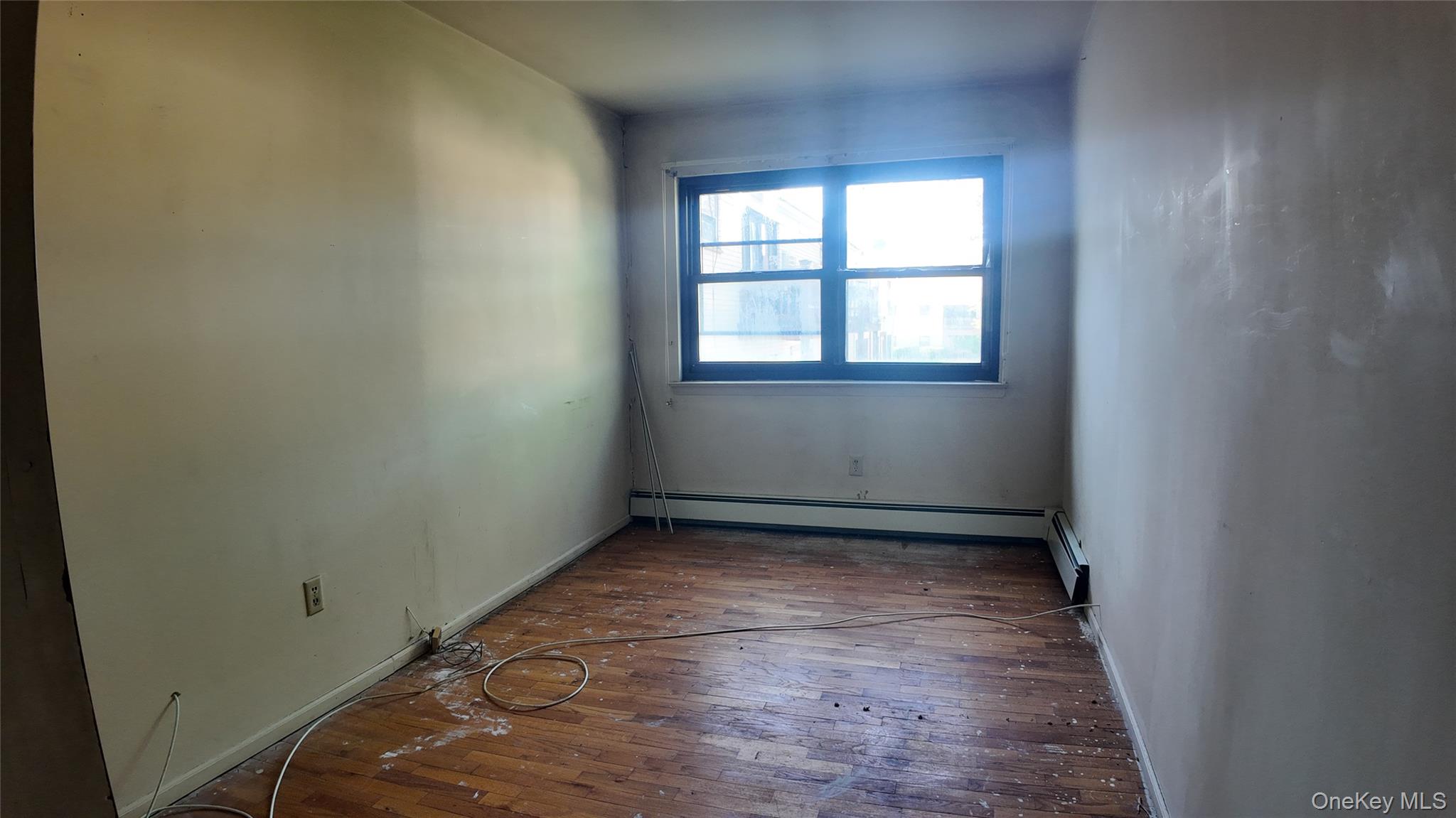 80 Sneden Place, Unit 80 Spring Valley, NY 10977 - Photo 3 of 5 an empty room with wooden floor and windows